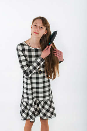 Closeup portrait girl brushing her hair on white backgroundの写真素材