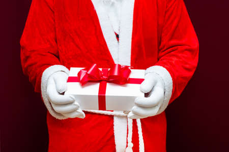 Cropped view of santa claus holding gift box.Close up front view selective focus.Christmas concept.の写真素材
