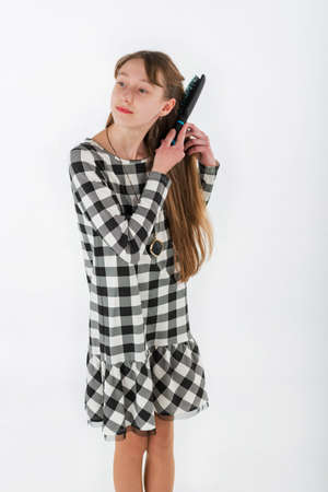 Closeup portrait girl brushing her hair on white backgroundの写真素材