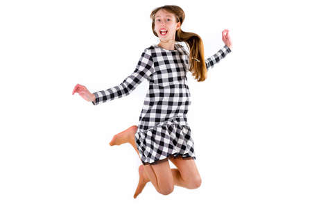 happy teen girl jumping up on white studio background.の写真素材
