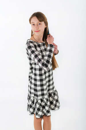 Closeup portrait girl brushing her hair on white backgroundの写真素材