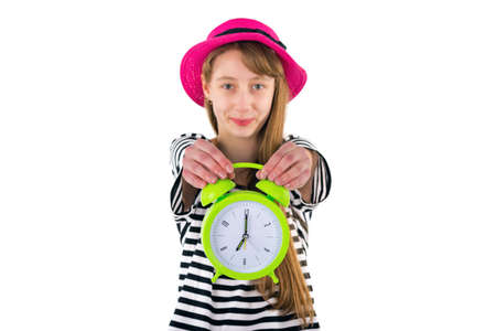 Teen Girl holding alarm Clock, isolated on white background. Portrait of caucasian teenager showing green alarm clock.Close up image.の写真素材