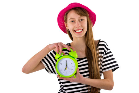 Teen Girl holding alarm Clock, isolated on white background. Portrait of caucasian teenager showing green alarm clock.Closeup.の写真素材