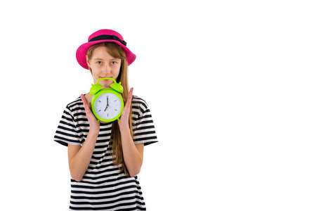 Teen Girl holding alarm Clock, isolated on white background. Portrait of caucasian teenager showing green alarm clock.の写真素材