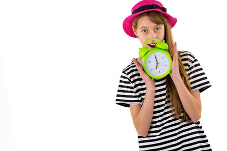 Teen Girl holding alarm Clock, isolated on white background. Portrait of caucasian teenager showing...