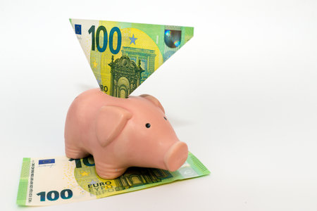 One hundred euros in a piggy bank. Over white background.Indoors shot.の写真素材