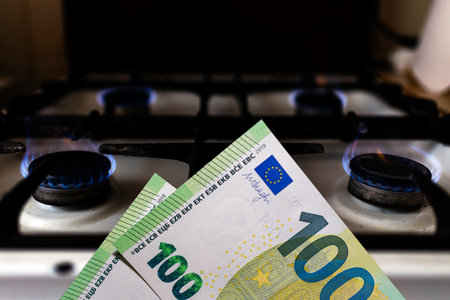 Money and stove.Burning stove flame and one hundred bills two denominations.Close up.の写真素材