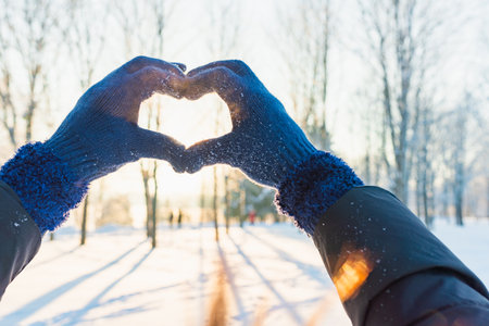 Valentine's Day, heart from hands, woman making heart symbol.Valentines day.Sunset winter outdoors background.の写真素材