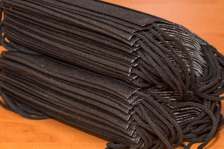 Pile of black face masks - medical concept.Dark background.Closeup image.