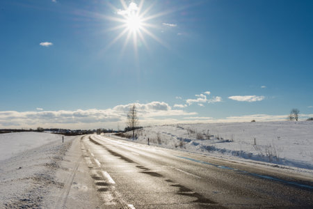 Winter road under blue sky,sun.Nice Rural road asphalt.の写真素材