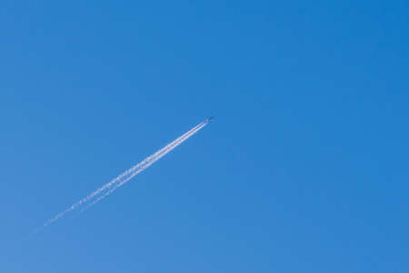 Small Airplane in the sky. An airplane trail across the blue sky