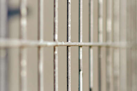Gray metal vertical stripes fence. Abstract gray background. Closeup.