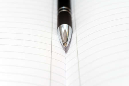 Pen and blank white sheet of paper closeup. Macro photography. The concept of notes, business, ideas. Black and white tones, minimalism.Black Elegant Ball Pen.の写真素材