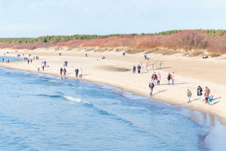 A Lot of people walking on the beach in spring.People walking on the beach in spring.Palanga,Lithuania 26 03 2021.のeditorial素材