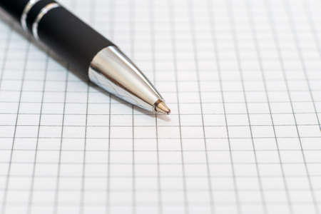 Ballpoint pen on the background of a sheet of checkered paper.Close up,macro shot.の写真素材