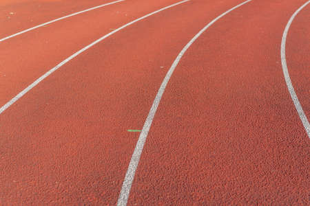 Part Red plastic track in the outdoor track and field stadium.Closeup.