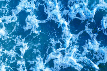 Areal shot of deep blue and rough sea with lot of sea spray.Blue background.Soft focus,blurred image.の写真素材