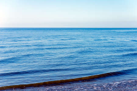 Areal shot of deep blue and rough sea with lot of sea spray.Blue background.
