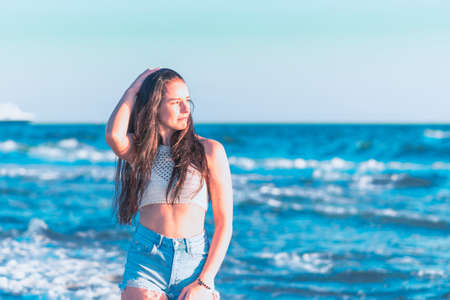 Young woman playing in the sea in summer. woman enjoying in sea water.Cheerful young woman having fun on the beach. She is relaxed in the sea water and enjoys on vacation.の写真素材