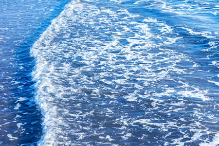 Areal shot of deep blue and rough sea with lot of sea spray.Blue background.Soft focus,blurred image.の写真素材