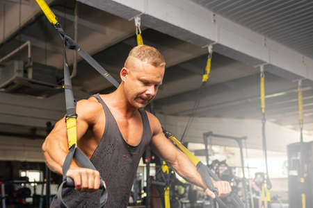 Muscular man working out in gym doing exercises,Exercise for triceps in the gym. strong male naked torso abs.Handsome man bodybuilder doing workout at gym indoors.の写真素材