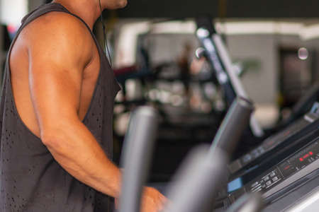 Young man in sportswear running on treadmill at gym.Handsome sport gym man running on the treadmill.Indoors shot.Man running in a gym on a treadmill.Exercising fitness.Healthy lifestyle concept.の写真素材