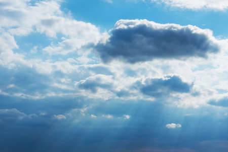 Dramatic blue sky with clouds and sun rays.Summer Sun rays at evening sunset.の写真素材