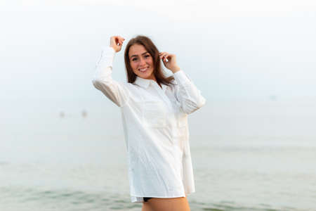 Young pretty fashion girl in white shirt. vacation at sea.Romantic Young Woman on Blue Natural...