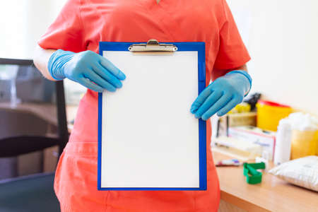 Doctor or nurse holding clipboard with blank sheet of paper in the laboratory.Blank space, copy...