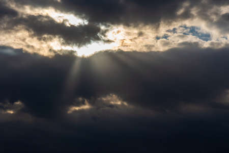 Rays of light shining throug dark clouds.Beautiful dramatic sky with sun rays.dramatic sky sun rays.