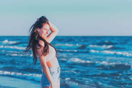 Young woman playing in the sea in summer. woman enjoying in sea water.Cheerful young woman having fun on the beach. She is relaxed in the sea water and enjoys on vacation.の写真素材