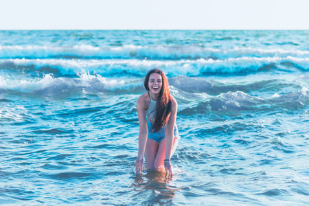 Young woman playing in the sea in summer. woman enjoying in sea water.Cheerful young woman having...