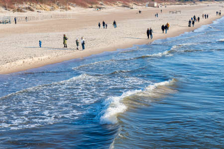 Several of people walking on the beach in spring.People walking on the beach in...