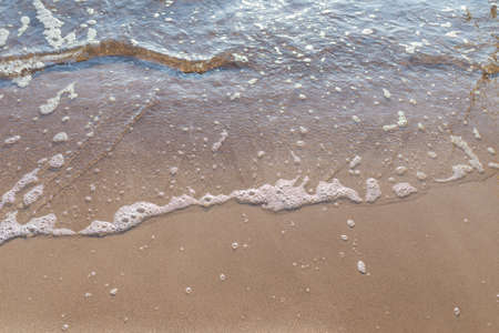 Soft wave of the sea on the sandy evening beach.Soft focus,blurred image.Copy space.の写真素材