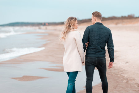 Loving couple relaxing on sandy beach. Love concept vacation.Back view.Spring,autumn vacation.の写真素材