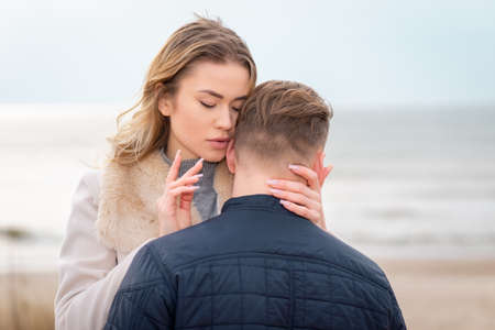 young beautiful stylish couple in spring on the beach. Hug each other and enjoy a warm spring evening.Closeup.の写真素材
