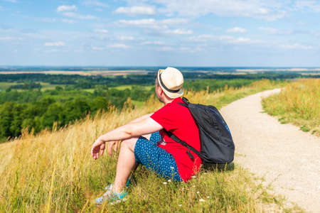 Traveler male relaxing meditation with serene view mountains forest landscape summer day. Man enjoying a view from the top of mountain. Relaxing middle age man alone with nature.Closeup,side view.の写真素材