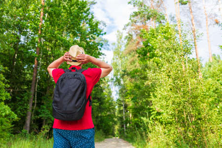 Caucasian male tourist in forest with his arms wide open. Copy space.Man backpacker arms outstretched in forest, freedom and active lifestyle concept.Summer day.の写真素材
