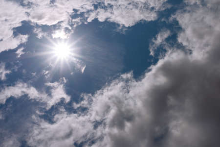 Rays of sunshine breaks through the dark clouds. Sun and blue sky with clouds.Concept of hope for the best, mood changes, enthusiasm, optimism,the breakthrough goal.blue sky and sun.の写真素材