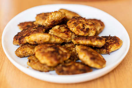 Homemade cutlets,meatballs white plate on a table yellow background.Delicious homemade cutlets at home on a white plate,wooden background. Selective focus.の写真素材
