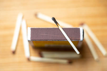 Selective focus of wooden matches,cardboard,burnt match.Matchsticks on yellow wooden blurred background.の写真素材
