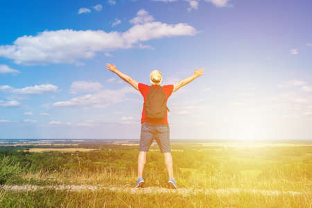Young man admiring beautiful view of the forest landscape rear view.Young man standing alone summer day outdoor with wild forest on background. Travel Lifestyle concept back viewの写真素材