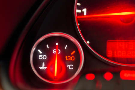 Car engine temperature sensor close up arrows.Lit red sign Overheating or norm,standart of the motor on the dashboard of the car close up.Blurred image.の写真素材