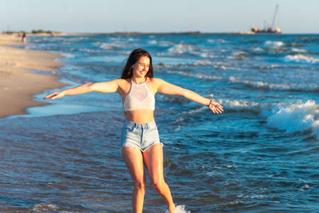Young woman playing in the sea in summer. woman enjoying in sea water.Cheerful young woman having fun on the beach. She is relaxed in the sea water and enjoys on vacation.の写真素材
