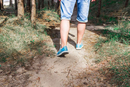 Man walking or running on path in forest summer natureo outdoors, sport shoes and exercising on fotpath.Closeup.の写真素材
