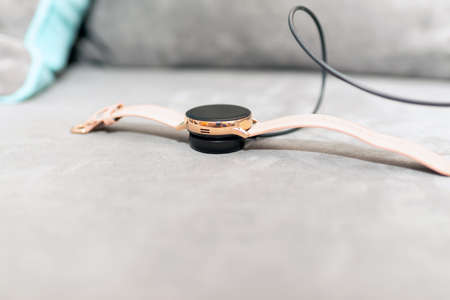 Smartwatch charging.Smart watch on wireless charging on the couch.Place for text.copy space.Blurred foreground.の写真素材