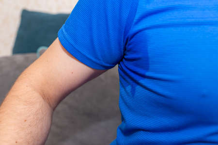 Man With Hyperhidrosis Sweating Very Badly Under Armpit.Man sweating excessively smelling bad at home.Closeup.の写真素材