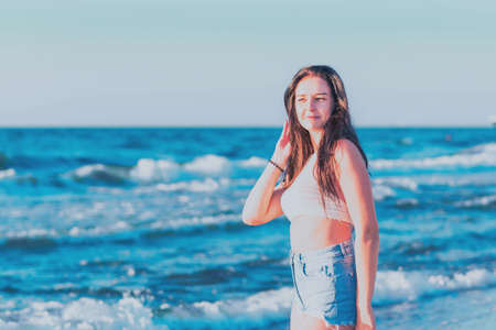 Young woman playing in the sea in summer. woman enjoying in sea water.Cheerful young woman having fun on the beach. She is relaxed in the sea water and enjoys on vacation.の写真素材