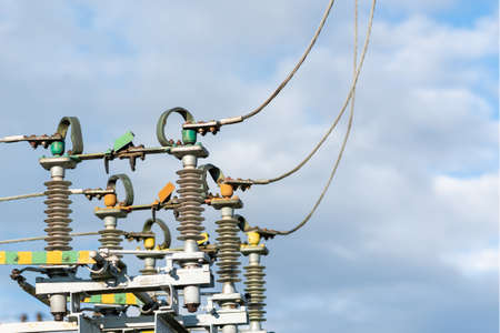 High voltage electric generator insulators.Detail of high voltage circuit breaker in a power substation.high voltage circuit breaker in a power substation on a summer cloudy day.Closeup.Copy space.の写真素材