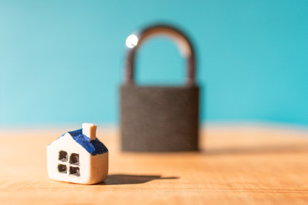 House locked with padlock. House is closed on a lock.Blue blurred background.Selective focus.Closeup.の写真素材
